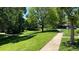 Well-manicured lawn with walking paths, mature shade trees, and view of neighborhood homes at 9005 E Lehigh Ave # 16, Denver, CO 80237