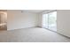 Spacious living room with neutral walls, plush carpeting, and a sliding glass door to the private balcony at 9005 E Lehigh Ave # 16, Denver, CO 80237