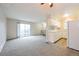 Bright living room with fresh carpeting, a sliding glass door to the balcony, and an open layout with views into the kitchen at 9005 E Lehigh Ave # 16, Denver, CO 80237