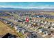 Expansive aerial shot showcasing a residential community, featuring single Gathering homes and mountain views in background at 802 Eva Peak Dr, Erie, CO 80516