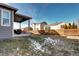 This backyard features a covered patio, green space, and a wooden fence at 802 Eva Peak Dr, Erie, CO 80516