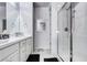 Clean bathroom featuring double sinks, white cabinets, and a glass-enclosed shower at 802 Eva Peak Dr, Erie, CO 80516