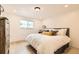 Bright bedroom with hardwood floors, a window, and a queen bed with decorative pillows at 5721 W 92Nd Ave # 96, Westminster, CO 80031
