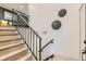 Elegant staircase features wooden steps, a sleek black railing, and decorative wall art at 5721 W 92Nd Ave # 96, Westminster, CO 80031