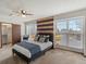 Comfortable bedroom with a ceiling fan, windows, and decoratively striped accent wall at 21258 E Aberdeen Pl, Centennial, CO 80015