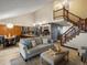 Open-concept living room showcasing natural light, a modern kitchen, and a striking staircase at 21258 E Aberdeen Pl, Centennial, CO 80015