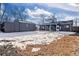 Backyard view with detached garage and patio, partially covered in snow at 3088 S Grape Way, Denver, CO 80222