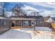 House backyard with detached garage and covered patio, partially covered in snow at 3088 S Grape Way, Denver, CO 80222