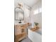 Modern bathroom with a bathtub and light wood vanity at 3088 S Grape Way, Denver, CO 80222