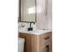 Modern bathroom vanity with black faucet and light wood cabinet at 3088 S Grape Way, Denver, CO 80222