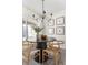 Modern dining room with round table, four chairs, and a stylish chandelier at 3088 S Grape Way, Denver, CO 80222