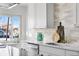 Modern kitchen with white cabinets, quartz countertops, and a gold faucet at 3088 S Grape Way, Denver, CO 80222