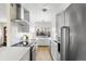 Bright kitchen featuring white cabinets, stainless steel appliances, and hardwood floors at 3088 S Grape Way, Denver, CO 80222