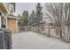 Large deck with wood railing, offering serene views of the snow-covered trees and surrounding area at 2522 W Dry Creek Ct, Littleton, CO 80120