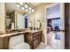 Bathroom with a granite vanity top, modern lighting, and neutral color scheme with view into bedroom at 2522 W Dry Creek Ct, Littleton, CO 80120