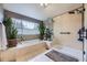 Serene bathroom showcasing a bathtub, walk-in shower, and large window with natural light at 2522 W Dry Creek Ct, Littleton, CO 80120