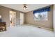 A large bedroom with neutral walls, white carpet, ceiling fan, and an ensuite bathroom at 2522 W Dry Creek Ct, Littleton, CO 80120