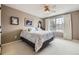 Comfortable bedroom with a large window, ceiling fan, neutral carpet, and light-colored walls at 2522 W Dry Creek Ct, Littleton, CO 80120