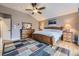 A cozy bedroom with light wood floors, wood furniture, a large area rug, and neutral colored walls at 2522 W Dry Creek Ct, Littleton, CO 80120