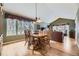 Open-concept dining area with a wooden table, seating for six, and large windows at 2522 W Dry Creek Ct, Littleton, CO 80120