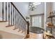 Welcoming foyer featuring hardwood floors, a staircase with wrought iron railings, and a stylish chandelier at 2522 W Dry Creek Ct, Littleton, CO 80120