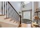 Bright and airy foyer featuring hardwood floors, a staircase, and a stylish chandelier at 2522 W Dry Creek Ct, Littleton, CO 80120