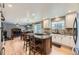 Open kitchen layout with island, stainless steel appliances, and seamless transition to the living and dining area at 2522 W Dry Creek Ct, Littleton, CO 80120