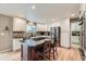 Spacious kitchen featuring a central island with bar seating, stainless steel appliances and white cabinets at 2522 W Dry Creek Ct, Littleton, CO 80120