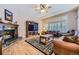 Inviting living room featuring a fireplace, hardwood floors, and large window shutters for natural light at 2522 W Dry Creek Ct, Littleton, CO 80120