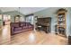 Bright living room with wood floors, a brown leather couch and view into the dining area at 2522 W Dry Creek Ct, Littleton, CO 80120