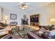 Spacious living room showcasing hardwood floors, a fireplace, comfortable seating, and a TV console at 2522 W Dry Creek Ct, Littleton, CO 80120