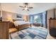 Comfortable main bedroom featuring hardwood floors, a ceiling fan, and a large bay window for natural light at 2522 W Dry Creek Ct, Littleton, CO 80120