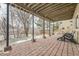 Covered brick patio with outdoor seating, supported by black beams, and views of the backyard at 2522 W Dry Creek Ct, Littleton, CO 80120
