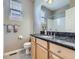 Bathroom with marble countertop, light wood cabinets, and a window that provides natural light at 13385 Jasmine St, Thornton, CO 80602