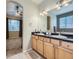 Bathroom featuring double sinks, tile flooring, and arched entryways at 13385 Jasmine St, Thornton, CO 80602