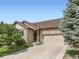 Inviting front exterior of a home featuring stone accents and a two-car garage at 13385 Jasmine St, Thornton, CO 80602