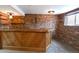 Basement bar area featuring a wooden bar, brick walls, and built-in shelving at 5063 W 61St Ave, Arvada, CO 80003