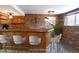 Basement wet bar has brick and wood design, complete with barstools and a view of a window at 5063 W 61St Ave, Arvada, CO 80003