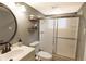 This bathroom features a modern vanity, framed round mirror and a glass-enclosed shower for a sleek and functional space at 5063 W 61St Ave, Arvada, CO 80003