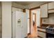 Bright kitchen featuring white refrigerator, wood cabinets, and hardwood floors throughout the home at 652 N Gilpin St, Denver, CO 80218