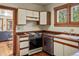 Cozy kitchen showcasing a stove, window, sink, stainless steel dishwasher and wood flooring at 652 N Gilpin St, Denver, CO 80218
