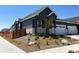 Landscaped front yard of a one-story grey home with white trim, including rock features and a privacy fence at 3401 N Denali St, Aurora, CO 80019