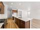 Kitchen island with sink and breakfast bar complements modern cabinets and bright, airy living space at 3401 N Denali St, Aurora, CO 80019