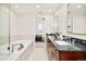 Bright bathroom with dual sinks, dark wood vanity, soaking tub, and glass enclosed shower at 3221 Perry St, Denver, CO 80212