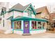 Charming, colorful two-story building with turquoise trim, a purple door, and decorative accents on the roof at 3221 Perry St, Denver, CO 80212