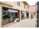 Street-level view of brick commercial building with Metalmark and Strut retail stores in Highland Square at 3221 Perry St, Denver, CO 80212