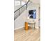 Hallway featuring modern desk, sleek black banister, and light hardwood flooring at 3221 Perry St, Denver, CO 80212