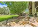 Serene backyard featuring a landscaped waterfall feature, a wooden deck and a patio seating area at 14118 Whitney Cir, Broomfield, CO 80023