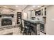 Basement bar with a glass countertop, unique wood base, fireplace and seating at 14118 Whitney Cir, Broomfield, CO 80023