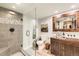 Bathroom featuring a frameless glass shower, rustic wooden vanity and a decorative mirror at 14118 Whitney Cir, Broomfield, CO 80023